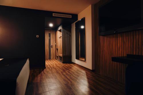 克雷塔罗Hotel Yoru的客房设有带木地板的走廊和电视。