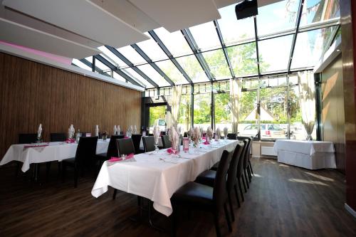 汉比伦族和露特酒店的一间带桌椅的用餐室和大窗户