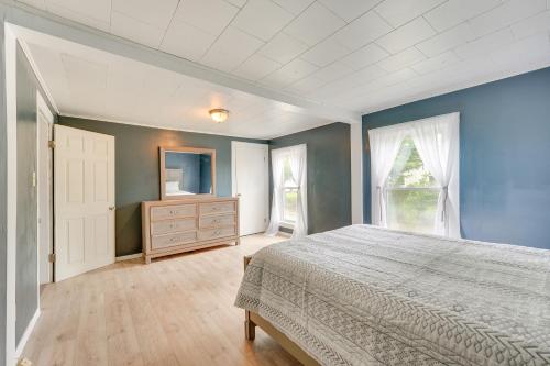 ClaremontOutdoorsy Oasis with Screened Porch in Claremont的一间拥有蓝色墙壁的卧室、一张床和一个梳妆台