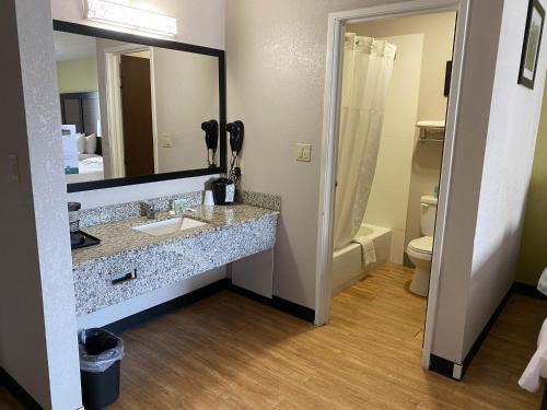 兰开斯特Motel 6 Lancaster的一间带水槽、镜子和卫生间的浴室