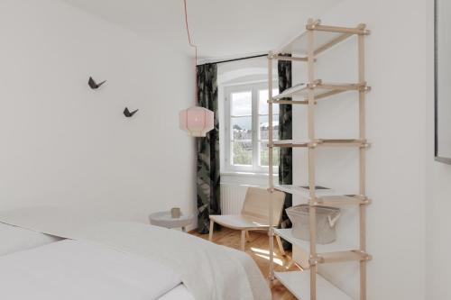 因斯布鲁克Das Grüne Haus - Boutique Apartments ecofriendly的卧室,床边设有书架