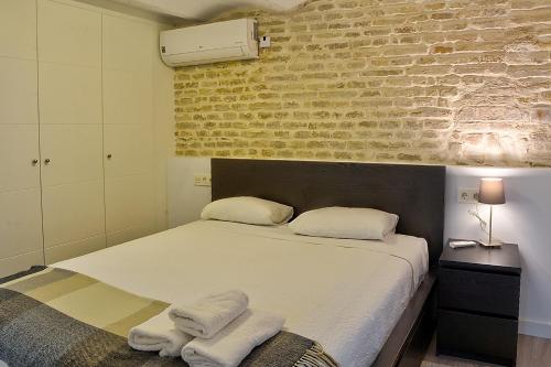 塞维利亚Duplex moderno en Alameda的一间卧室配有带毛巾的床