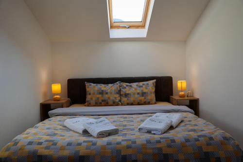 皮罗特Vila Nemir Zavojsko jezero的一间卧室配有一张床,上面有两条毛巾