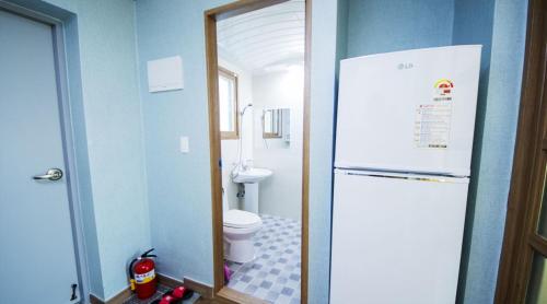 顺天市Suncheon Bay Ecology Pension的一间带白色冰箱和卫生间的浴室
