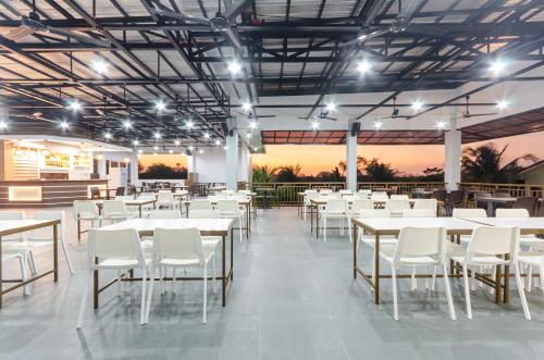 Magsaysay Hillside Resort powered by Cocotel的一间设有白色桌子和白色椅子的餐厅