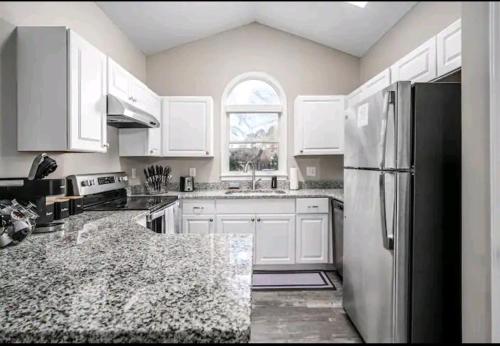 落基山Beautiful home的厨房配有白色橱柜和黑色冰箱。