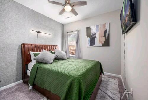 落基山Beautiful home的一间卧室配有一张绿色的床和吊扇