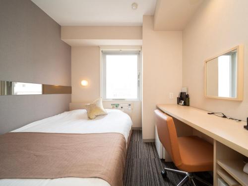 东京Super Hotel Premier Akasaka的酒店客房配有两张床和一张书桌