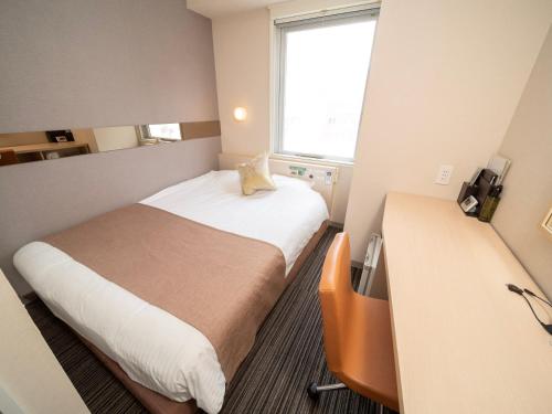 东京Super Hotel Premier Akasaka的酒店客房设有床和窗户。