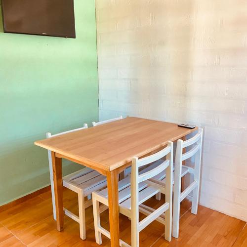 圣佩德罗·德·阿塔卡马Casa TAQI的一张木桌,四周摆放着四把白色椅子