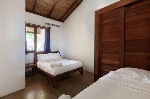 南圣胡安Casa Yosi, Beach Front Piece of Heaven的一间卧室设有两张床和窗户。