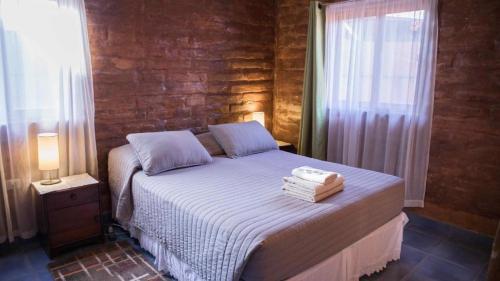 圣佩德罗·德·阿塔卡马索洛旅馆的一间卧室配有一张床,上面有两条毛巾