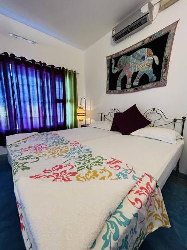 科钦Chameleon Beach Resort, Cherai的一间卧室设有两张床,墙上挂着一张大象照片