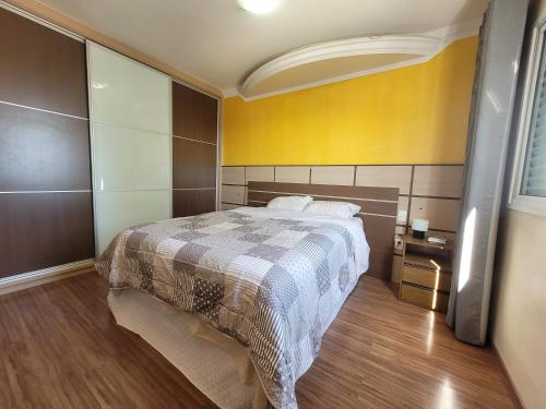 圣若泽杜斯坎普斯Apto espaçoso no Aquarius的一间卧室设有一张床和黄色的墙壁