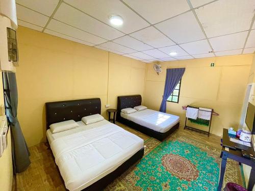 TumpatDGeting Beach Resort的客房设有两张床、一张桌子和一扇窗户。