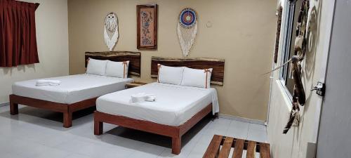 巴利亚多利德Casa Yaxkin的一间卧室配有两张带白色床单的床