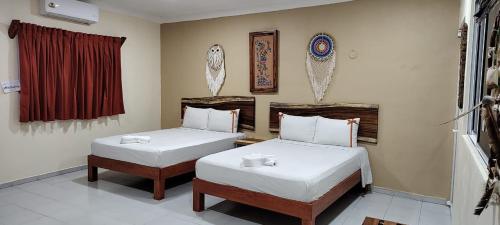 巴利亚多利德Casa Yaxkin的客房设有两张床和窗户。