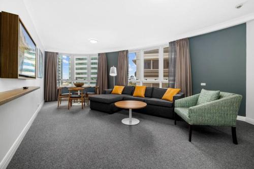 悉尼Chatswood Hub Self- Catering 815的客厅配有沙发、椅子和桌子