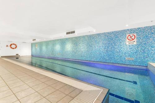 悉尼Chatswood Hub Self- Catering 815的蓝色瓷砖健身房内的游泳池