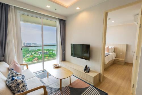 是拉差Yuu Residence的客厅设有大窗户和电视。