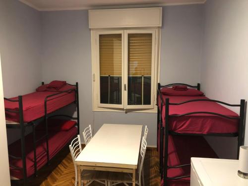 摩德纳Euro House的客房设有两张双层床、一张桌子和一扇窗户。