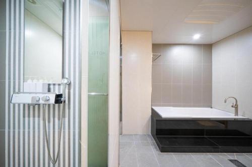 NajuHotel Core的带淋浴、浴缸和盥洗盆的浴室
