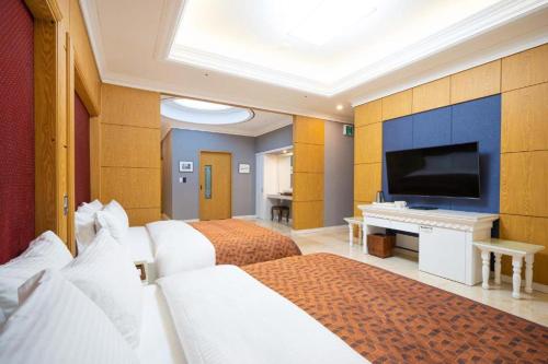 NajuHotel Core的酒店客房设有两张床和一台平面电视。