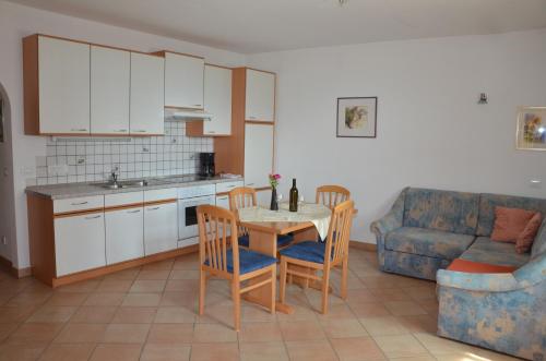 阿皮亚诺苏拉斯特拉达Ansitz Weissenheim的厨房配有桌椅和沙发。