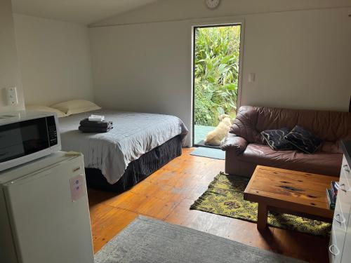 奥波蒂基Kukumoa Cabin的客厅配有床和沙发