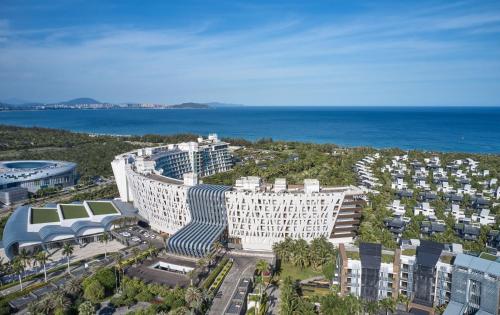 三亚三亚海棠湾民生威斯汀度假酒店(享免税店9.5折)的靠近大海的大建筑的空中景观