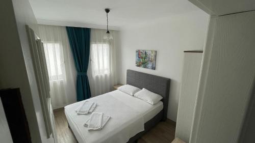 达特恰Gülhan City Otel的一间卧室配有一张床,上面有两条毛巾