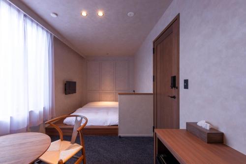 金泽NODE SAIGAWA的一间卧室配有一张床、一张桌子和一张桌子