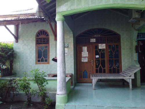 塞里布群岛Losmen Lima Saudara的门前有长凳的建筑物