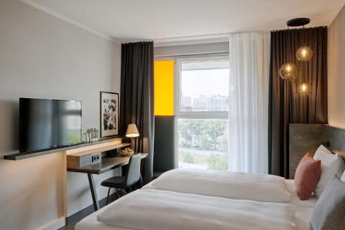 汉堡THE SCOTTY Hotel Hamburg的酒店客房设有一张床、一张书桌和一台电视机。