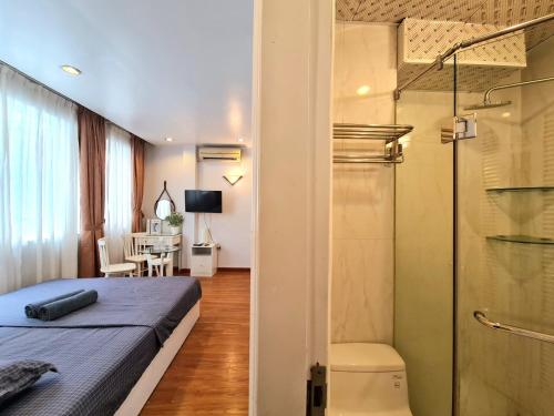 河内Libré Homestay Đào Tấn的一间卧室设有一张床和一个玻璃淋浴间