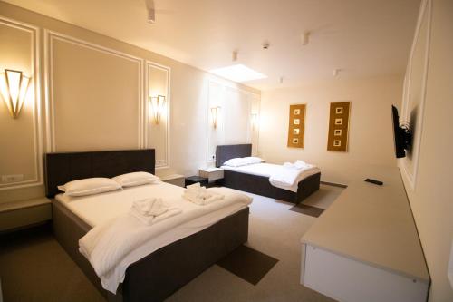 布泽乌HOTEL GLAMOUR IMPERIAL的酒店客房设有两张床和一张桌子。