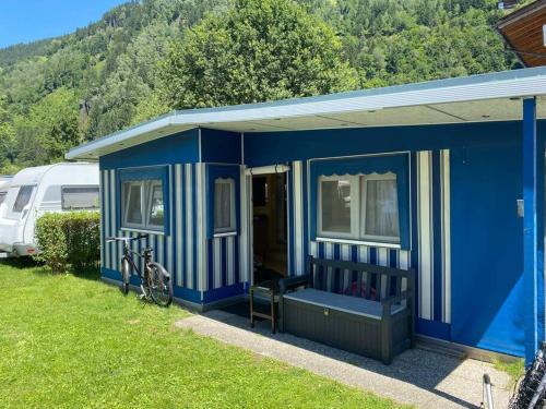 阿绍***** Camping Aufenfeld - Sonnenglückhütte的蓝色的房子,前面有一辆自行车停放