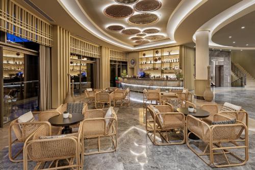 GuvercinlikTitanic Luxury Collection Bodrum的一间带桌椅的餐厅和一间酒吧