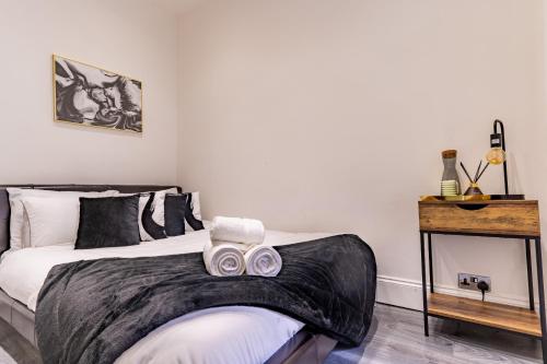 伦敦Prime Location - Cosy Apartment near Emirates Stadium的一间卧室,配有一张带两个面罩的床