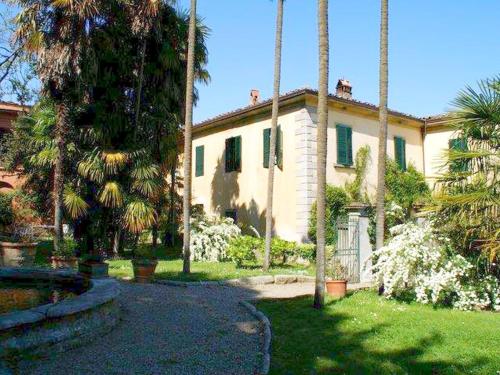 卡尔米尼亚诺Cosy Farmhouse in Bacchereto with Swimming Pool的一座大房子,在院子里种有棕榈树