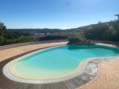 利斯西亚迪维卡Residence Gli Oleandri 140 - Costa Smeralda - Porto Cervo的砖院里的一个大型游泳池