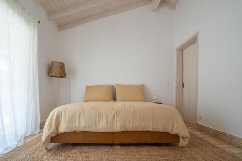 塞卡尔Vale da Cassiopeia的白色卧室配有床和灯