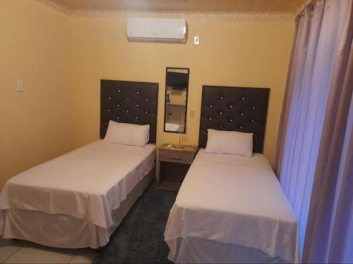 勒斯滕堡Maboe Leisure Resort的带两张床和镜子的客房