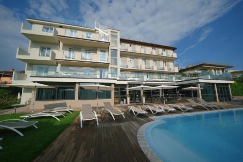 代森扎诺-德尔加达Hotel Palazzo del Garda & Spa的一座带游泳池和椅子的酒店和一座建筑