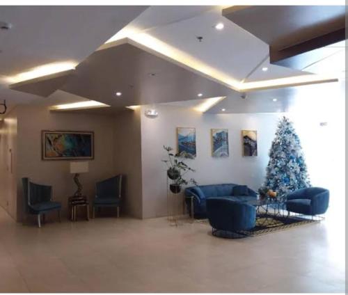 宿务Sunvida Tower Across SM City Cebu的客厅配有圣诞树和蓝色家具