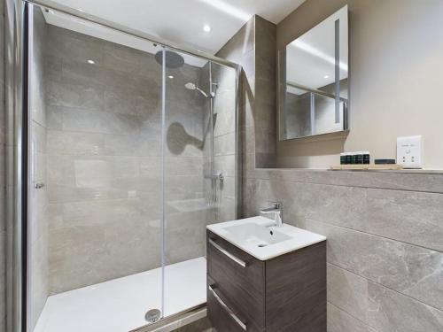 贝尔法斯特Bradbury Apartment on Lisburn Road by Lesley的带淋浴、盥洗盆和镜子的浴室