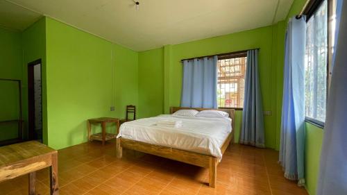 万荣sokxay guerthouse的绿色卧室设有床和窗户