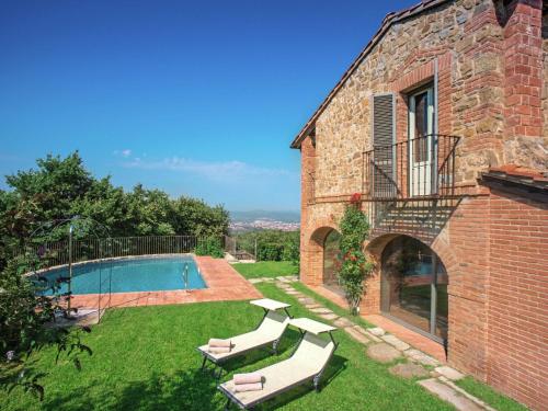阿雷佐Ritzy Villa on a Wine Estate in Arezzo with Pool的后院设有游泳池和砖砌建筑