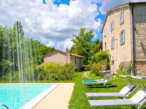 阿夸拉尼亚Pretty Holiday Home in Acqualagna with Swimming Pool的一座带喷泉的建筑前的游泳池