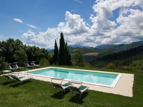 阿夸拉尼亚Pretty Holiday Home in Acqualagna with Swimming Pool的一个带椅子的游泳池,享有山景